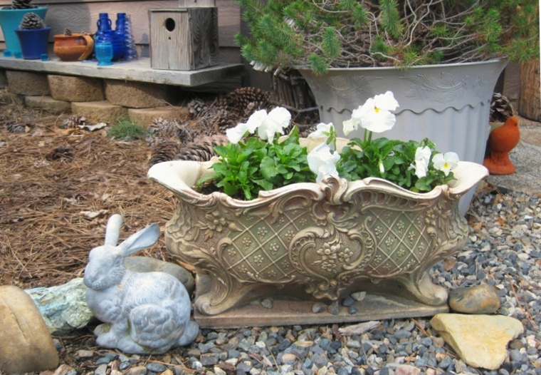 2011 Easter violas A low urn filled with crisp white pansies, verdigris rabbit and heart stone in Sue Langley's entry garden